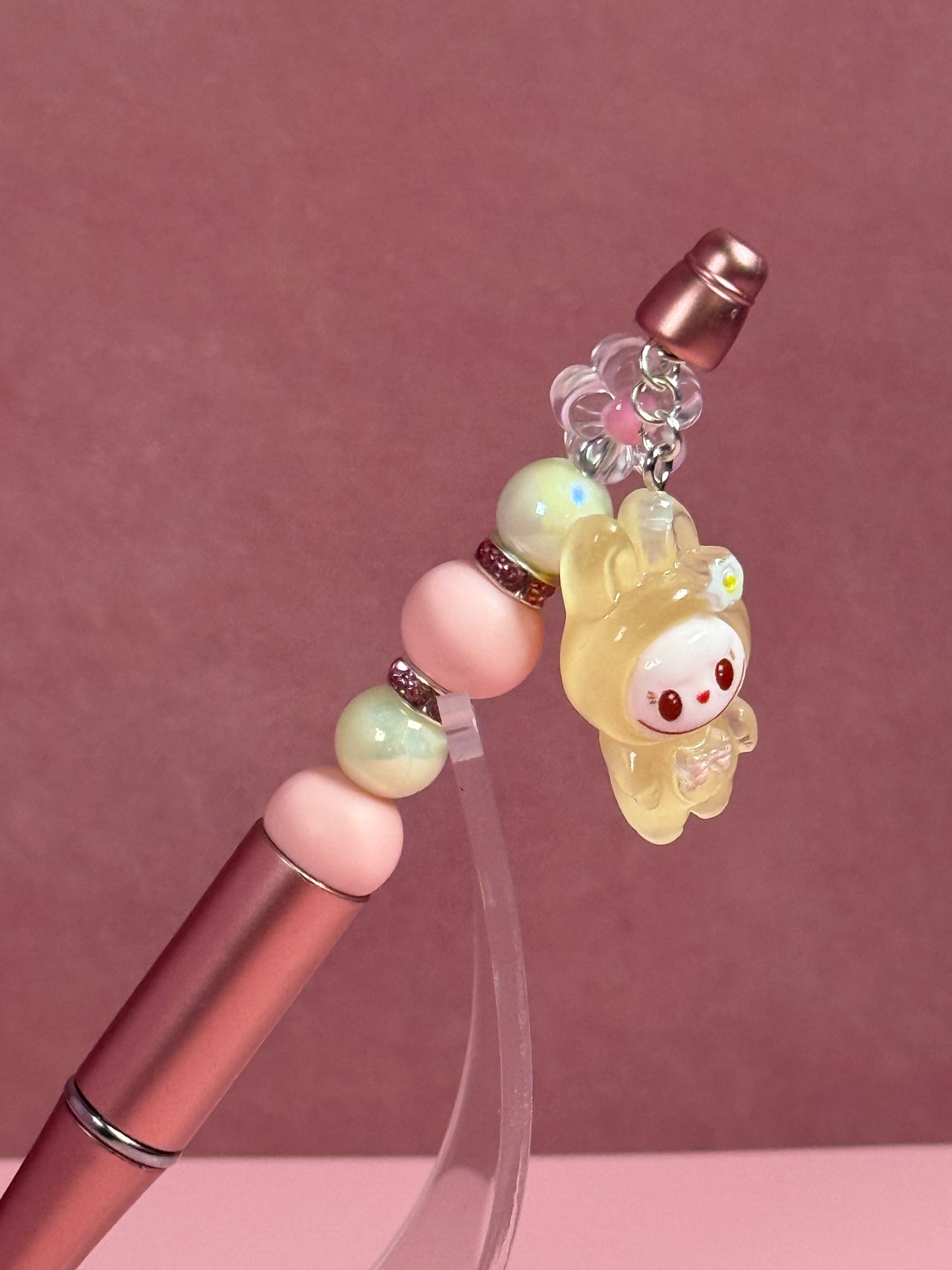 Closer view of a Handmade metallic pink beaded pen inspired by the Labubu Character, featuring pink and light green beads and a yellow
Labubu character charm