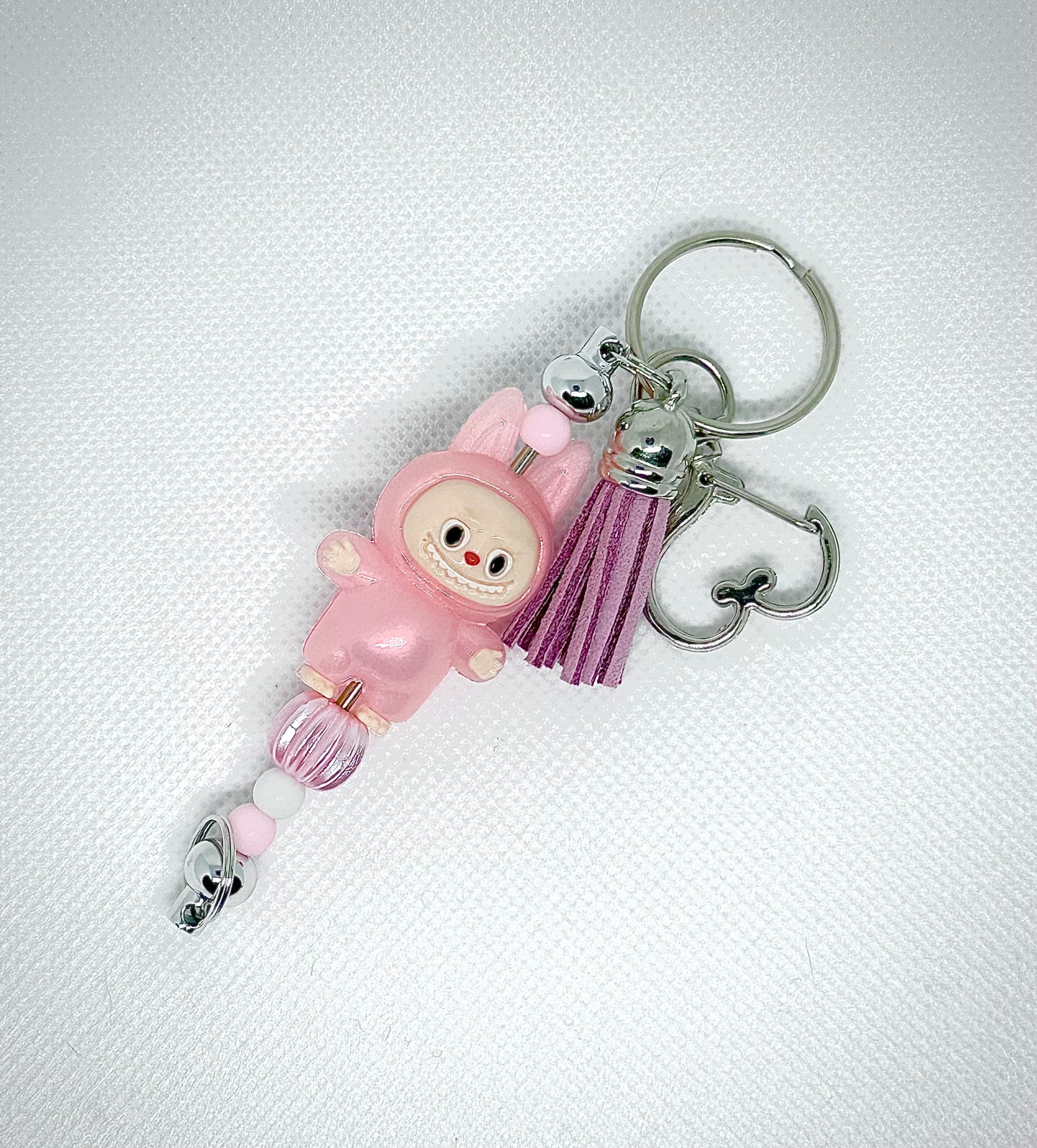 Handmade silver key chain inspired by the Labubu character. Featuring leather tassel and pink Labubu character charm. Perfect
For Labubu fans and collectors. 